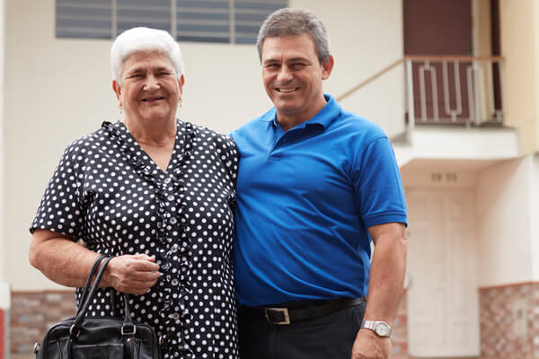 Hombre con su madre pensionada quien está feliz al ser respaldada por el Banco a través de su Tarjeta de Crédito Amigos de la Experiencia.