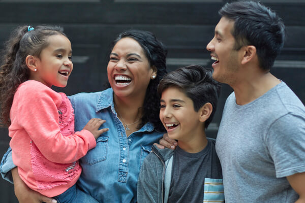 Familia que se encuentra feliz al saber que su vivienda está protegida por una Póliza Hogar del Banco Caja Social