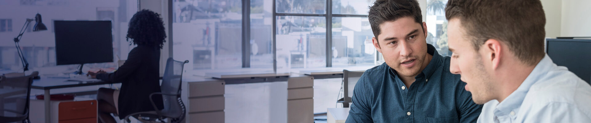 Par de hombres que hablan de cómo invertir en un  DíaDía del Banco Caja Social para poner a producir las ganancias de su microempresa.
