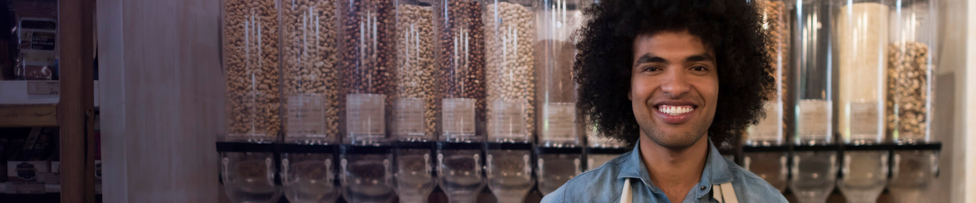 Joven con delantal y pelo afro,  es un emprendedor exitoso. Con su creatividad y los productos de ahorro e inversión, su negocio crece.