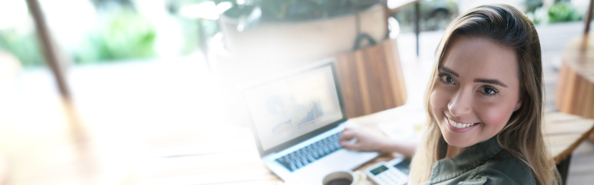 Cuenta de Ahorros Empresarial Mujer joven sonríe mirando a la cámara. Nunca imaginó que su empresa creciera tanto, y cuánto le apoyaría la cuenta de ahorros empresarial.