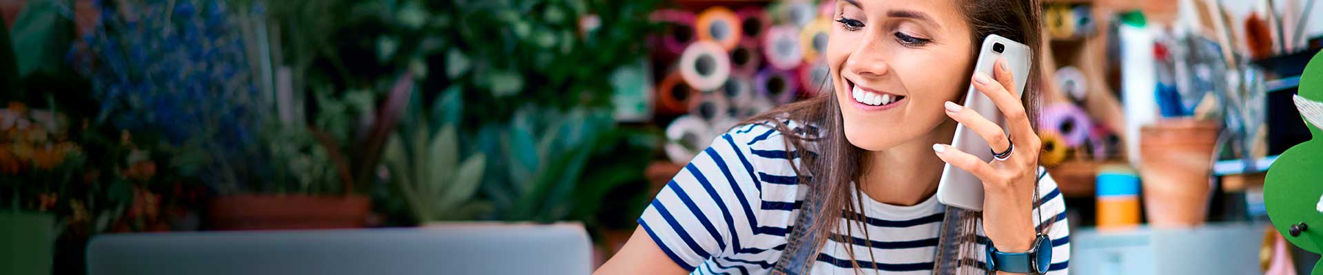 La dueña de una floristería ha llamado desde su celular al teléfono ce contacto para Pymes, sonríe mientras la atienden.